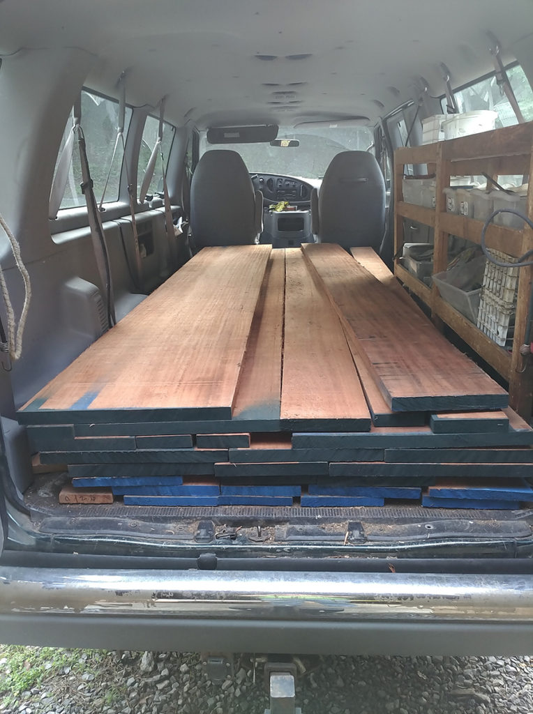 Pile of raw mahogany ready to be planed for custom exterior doors