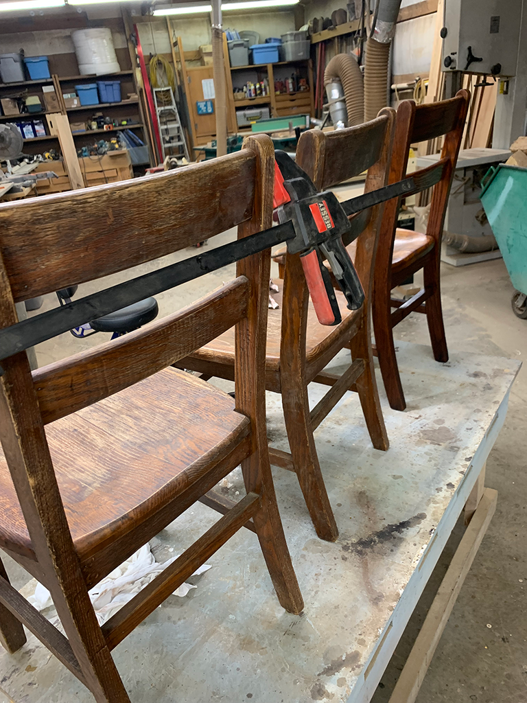 Chairs held with steel bar clamps during repair